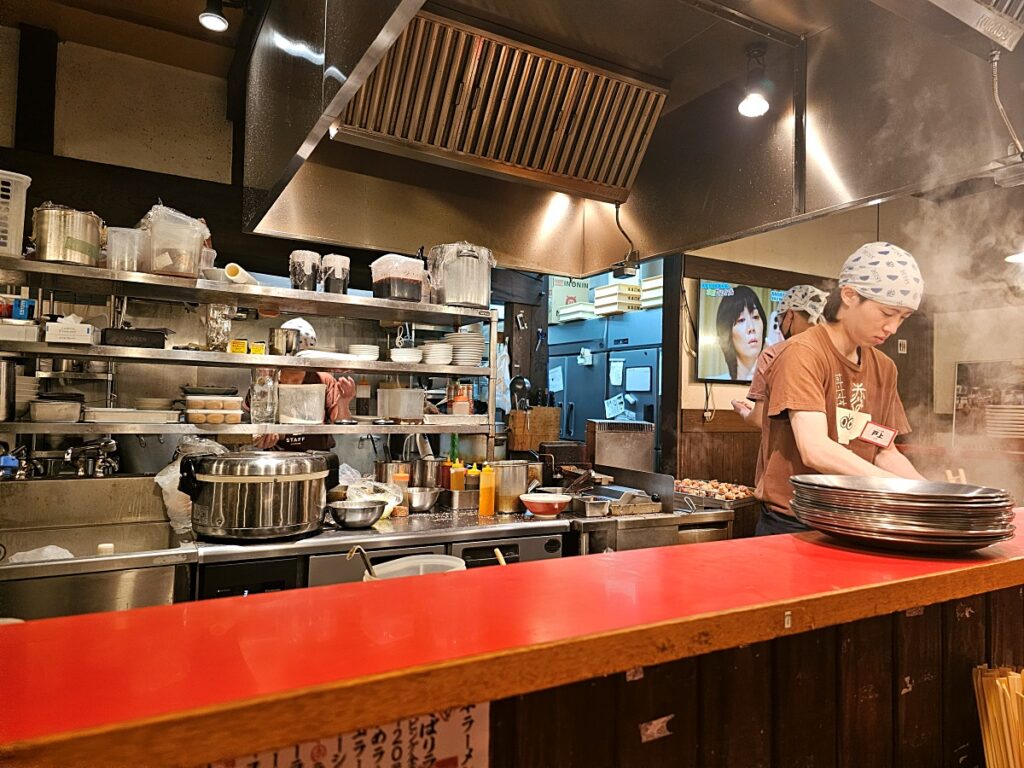 활기찬 분위기의 구마모토 아카구미 라멘 가미토리점 오픈 주방
