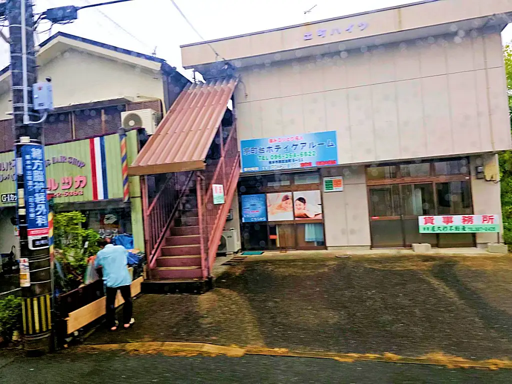 비 오는 날 버스 창밖으로 보이는 구마모토 시외의 한적한 상가 풍경