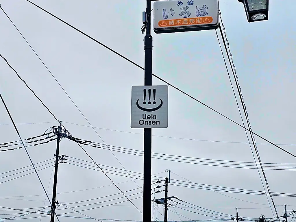 길가에 설치된 우에키 온천 공식 엠블럼과 안내 표지판